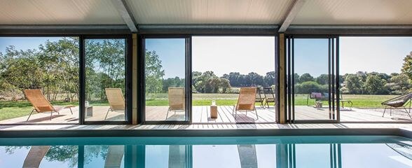 Piscine avec vue sur le jardin du gîte Le Chromatic